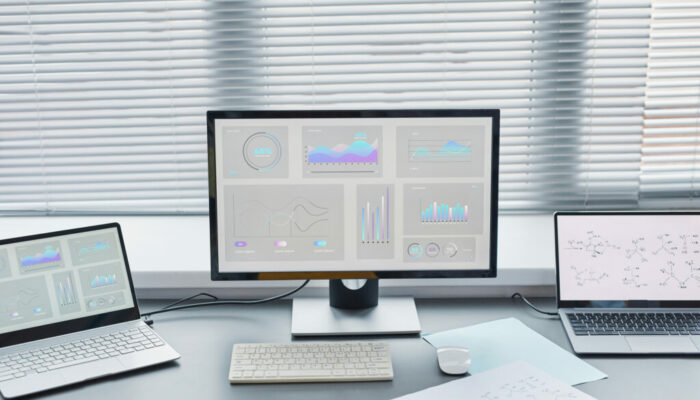 Close-up of computer with big monitor with charts on the screen standing on the table in the lab